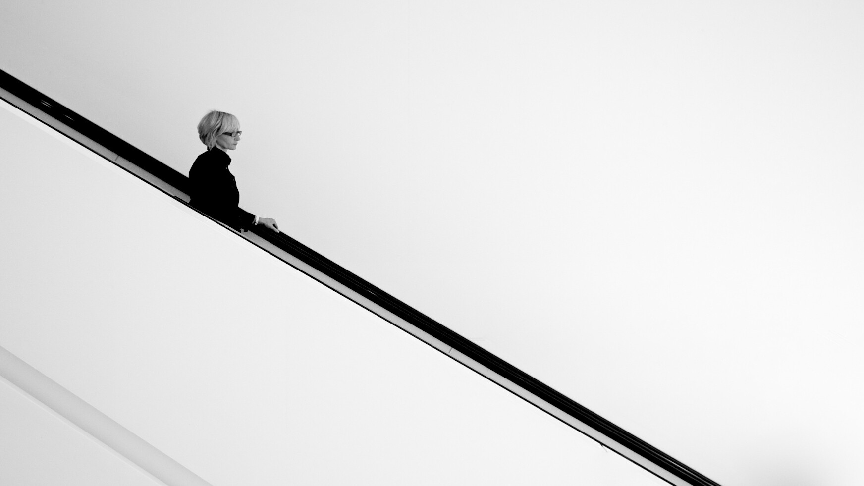 spazio vuoto nella fotografia, donna con occhiali su scale nerel